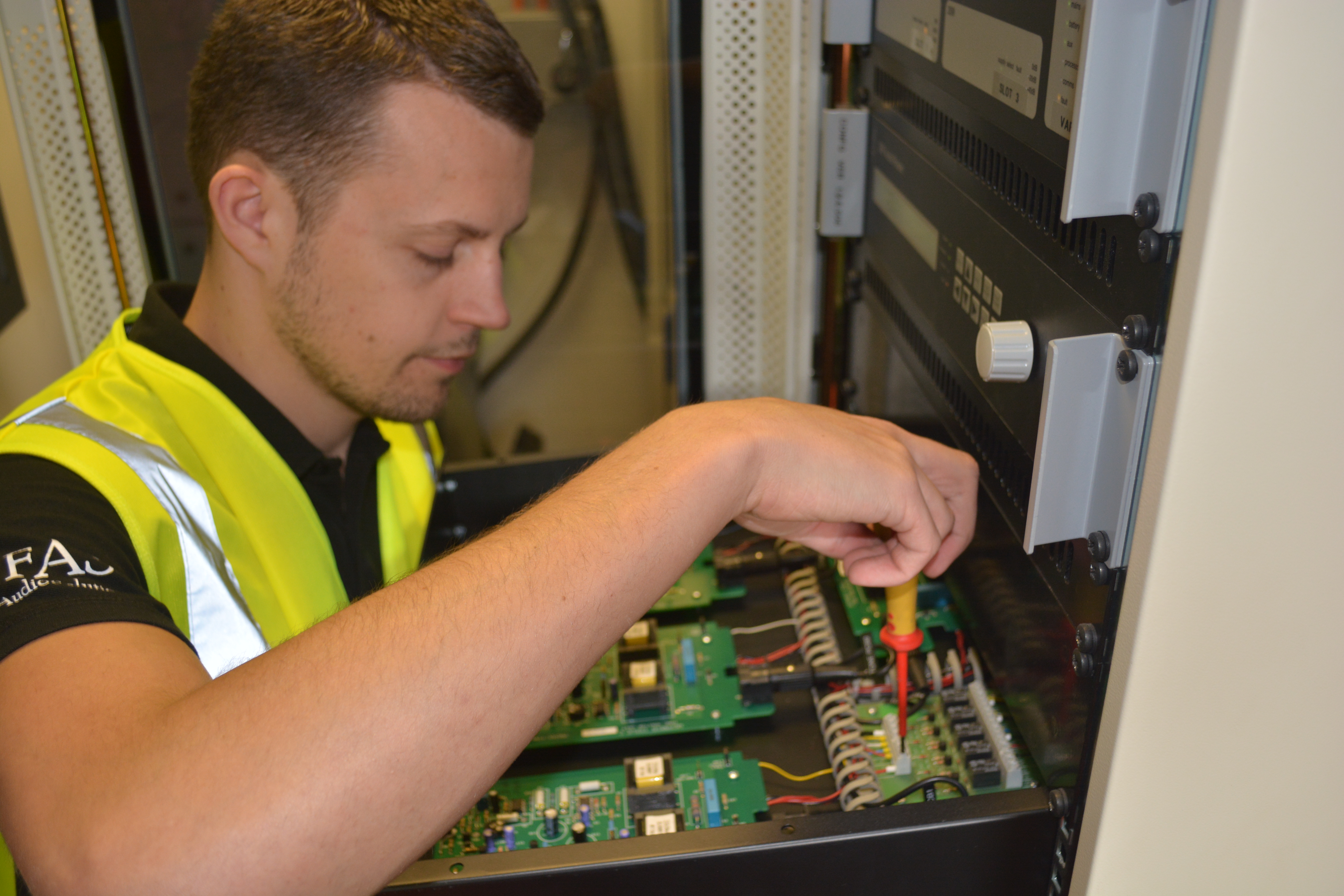 Engineer carrying out commercial fire alarm repair work